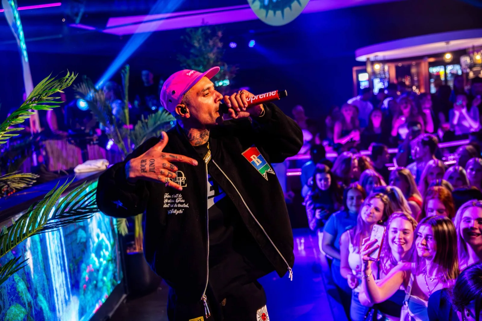 Rapper met roze pet en microfoon voor een vol publiek